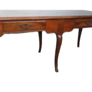 May include: A vintage wooden desk with three drawers and cabriole legs. The desk is made of dark wood and has a simple, elegant design.