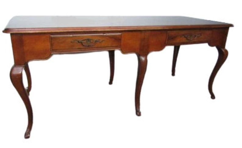May include: A vintage wooden desk with three drawers and cabriole legs. The desk is made of dark wood and has a simple, elegant design.