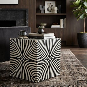 May include: A cube-shaped side table featuring a high-contrast black and white geometric pattern of repeating curved lines. The table has a flat top surface and a square silhouette, displaying a bold, symmetrical design that covers all visible sides.