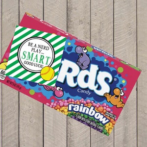 May include: A box of Rds Rainbow Candy with a green and white striped tag that says "Be a nerd play... SMART good luck!" and a yellow softball.