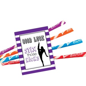 May include: A purple and white striped card with the words "GOOD LUCK Stix those Kicks" and a silhouette of a gymnast doing a split. Several Pixy Stix candies in various colors are arranged around the card.