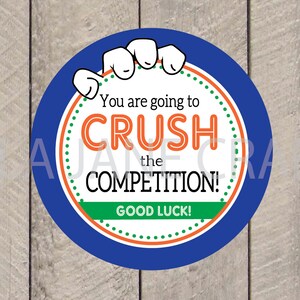 K&ouml;nnte beinhalten: Ein blauer Kreis mit einer wei&szlig;en Hand, die den Kreis h&auml;lt. Der Kreis hat einen wei&szlig;en Hintergrund mit gr&uuml;nen und orangefarbenen Punkten. Der Text "You are going to CRUSH the COMPETITION! GOOD LUCK!" ist in Orange und Schwarz geschrieben.