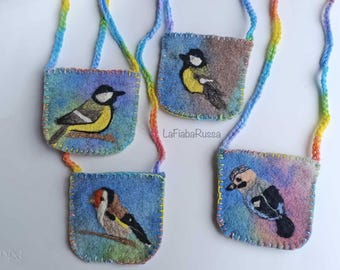May include: Four small, square felt pouches with colorful bird illustrations and rainbow straps. Each pouch features a different bird design, stitched onto a blue and purple background. The text "LaFiabaRussa" is visible.