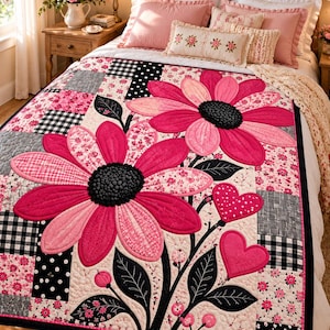 Könnte beinhalten: Eine Patchwork-Steppdecke mit großen, rosafarbenen Blumenapplikationen mit schwarzen Zentren, zwei herzförmigen Applikationen und schwarzen Stielen mit Blättern. Die Decke besteht aus verschiedenen quadratischen Blöcken mit schwarz-weiß-rosa Mustern wie Vichy und Punkten.