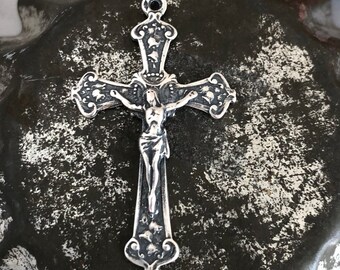 May include: Silver-toned crucifix pendant with a detailed design. The crucifix features a figure of Jesus Christ on the cross.