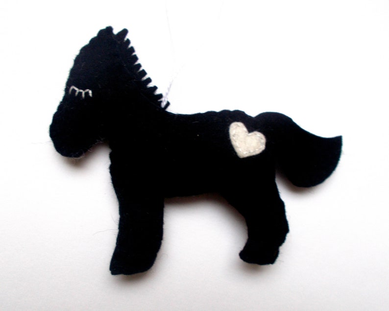 May include: Black felt horse ornament with a white felt heart on its side.