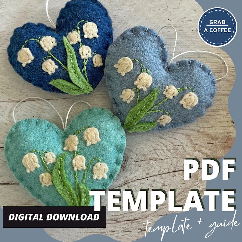 Puede incluir: Tres adornos de fieltro en forma de coraz&oacute;n en tonos azules y turquesas, cada uno adornado con flores de lirios de los valles bordadas. Los adornos tienen cuerdas blancas para colgar. El texto en la imagen dice "PDF TEMPLATE" y "DESCARGA DIGITAL".