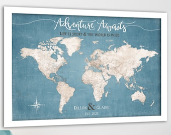 May include: A blue and white world map print with the text "Adventure Awaits, Life is short & the world is wide". The map is framed in white and has the names "Dillon & Glaire" and "Est. 2021" printed below the map.