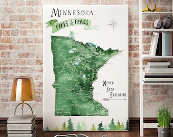 Può includere: Una mappa acquerellata verde del Minnesota con il testo "Minnesota Parks & Trails" e "Never Stop Exploring" con una bussola e una freccia. La mappa è circondata da un bordo di pini verdi.