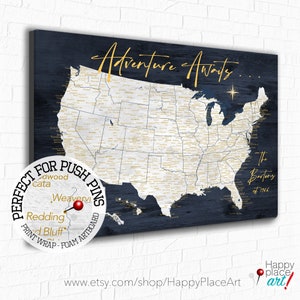 May include: A navy blue canvas map of the United States with gold lettering and state names. The map is titled "Adventure Awaits..." and has a gold star in the upper right corner. The map is framed and ready to hang. The text "The Bartons est 1986" is in the lower right corner. The text "Perfect for Push Pins" is in a circle in the lower left corner.
