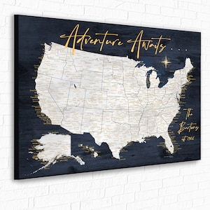 May include: A blue and white map of the United States with the text "Adventure Awaits..." and "The Bartons est. 1996" printed on it. The map is on a canvas with a wood grain texture.