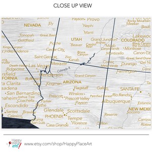 May include: A map of the southwestern United States with state borders outlined in dark blue and city names in gold. The map is printed on a wood-grain background. The map includes the states of Nevada, Utah, Arizona, Colorado, and New Mexico. The map also includes the cities of Las Vegas, Phoenix, Denver, and Santa Fe.