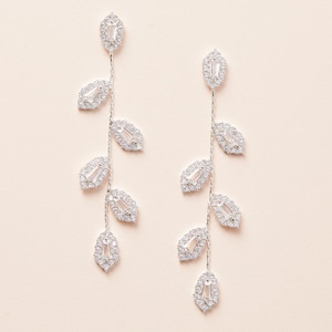 May include: Silver dangle earrings with a leaf design and clear cubic zirconia stones.