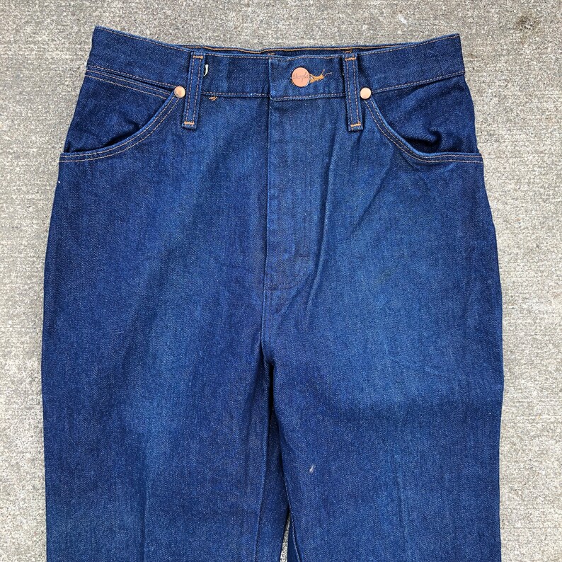 May include: A pair of dark blue denim jeans with a high waist and a straight leg.