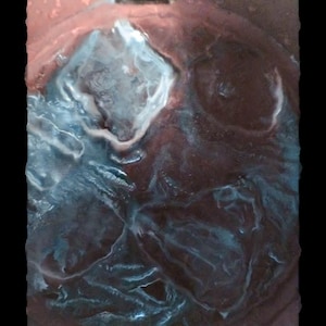 May include: A dark brown, circular, translucent resin coaster featuring embedded, swirling, light blue and white marbled patterns that create a textured, organic appearance with a glossy finish and uneven, wavy edges.