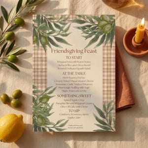 Puede incluir: Una tarjeta de menú rectangular titulada Friendsgiving Feast con fondo beige claro y borde de cuadros rosa y tostado. El diseño presenta ramas de olivo en acuarela en las esquinas. El texto enumera platos como To Start, At The Table, Something Sweet y To Sip, impresos en una fuente serif de color marrón oscuro.