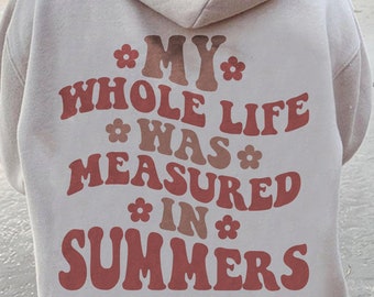 May include: A white hoodie with a red and brown graphic print that says "My whole life was measured in summers".