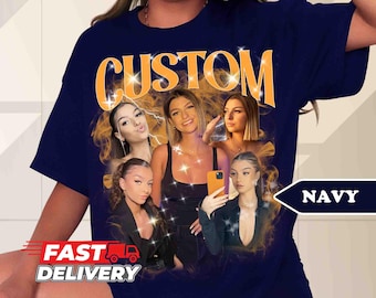 May include: Navy blue t-shirt with a graphic print of five women and the word "CUSTOM" in orange. The women are wearing different outfits and have different hairstyles. The t-shirt is a casual style and has a relaxed fit.