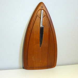May include: A wooden cutting board shaped like a triangle with a small knife attached to it.