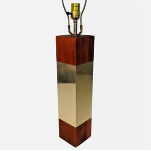 May include: A mid-century modern table lamp with a wooden base and a brass band. The lamp has a simple design and is perfect for a living room or bedroom.