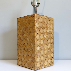 May include: A woven wicker lamp base with a square shape and a light brown color.