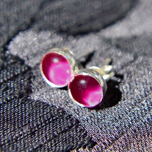 Puede incluir: Un par de pendientes de plata con piedras de ágata rosa y blanca.