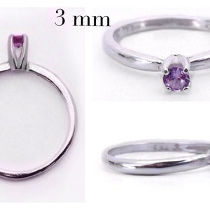 May include: A silver ring with a 3 mm amethyst gemstone. The ring is simple and elegant, with a delicate band and a single stone.