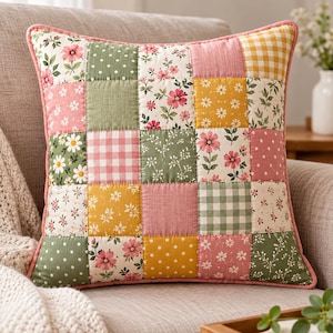 May include: A square throw pillow featuring a patchwork design of various fabric squares. The pattern includes floral prints, white polka dots on green, and pink and green gingham checks in shades of pink, yellow, sage green, and white.