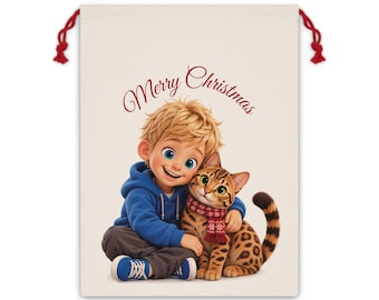 May include: A cream-colored drawstring gift bag featuring a graphic of a blonde child in a blue hoodie hugging a spotted cat wearing a red patterned scarf. The text Merry Christmas is printed in red script above the child and the cat.