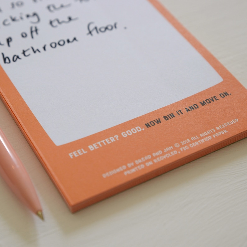 An orange notepad with the title 'Moan and Move On' for people to write down the things that they want to moan about.