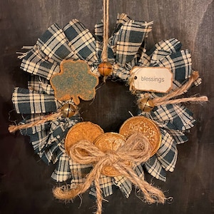 May include: A green and white plaid fabric wreath with a shamrock, gold coins, and a tag that says "blessings".