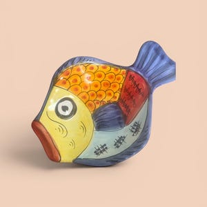 May include: A ceramic fish-shaped dish featuring a vibrant yellow face, orange scales, and a blue tail. The body is decorated with black line patterns, including cross-hatching and zigzags, against a multi-colored background of red and blue.