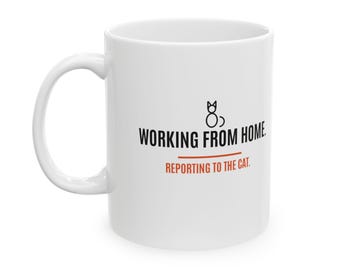 Può includere: Una tazza in ceramica bianca con un disegno a linee nere di un gatto sopra il testo nero WORKING FROM HOME. Sotto, una linea arancione separa il testo dalla frase arancione REPORTING TO THE CAT.