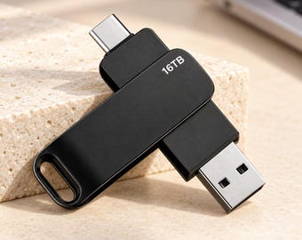 Può includere: Una chiavetta USB nera a doppio connettore con una spina USB-C argentata su un'estremità e una spina USB-A standard sull'altra. Il corpo del dispositivo è nero opaco con la scritta 16TB stampata in bianco e include un piccolo occhiello.