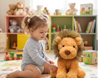 May include: A plush lion toy with golden-yellow fur and a dark brown mane, sitting on a patterned play mat. The stuffed animal features a soft, rounded face with a brown nose and small ears, designed with a textured, fuzzy fabric finish.