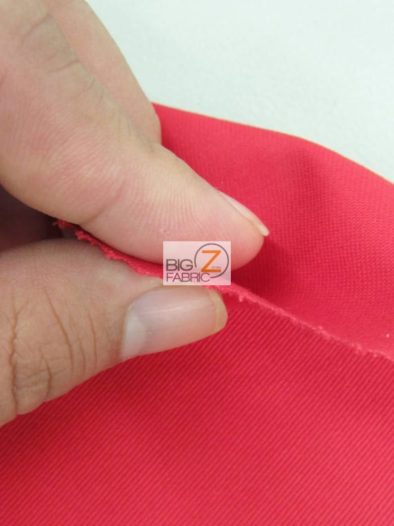 May include: Close-up of a bright red fabric with a textured weave. The fabric is being held in a hand, showing the texture and drape.