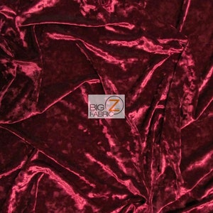 Puede incluir: Primer plano de una tela de terciopelo aplastado de color rojo oscuro. La tela tiene una textura suave y aterciopelada y un brillo sutil.