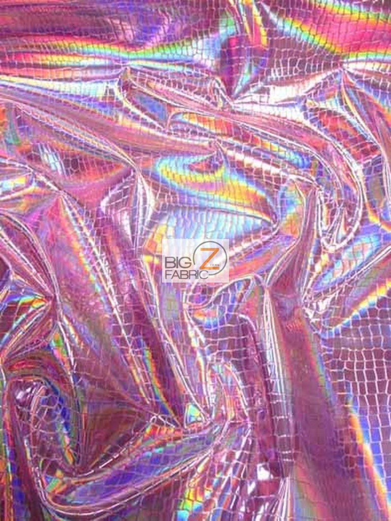 May include: Pink iridescent fabric with a crocodile pattern. The fabric is shiny and has a holographic effect.