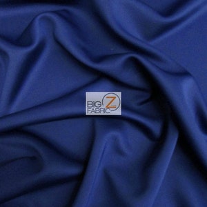 May include: Close-up of a smooth, dark blue fabric. The fabric is folded and draped, showing its texture and color.