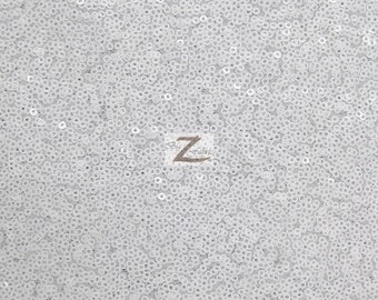 May include: White sequin fabric with a subtle pattern. The sequins are small and closely spaced, creating a shimmering effect.