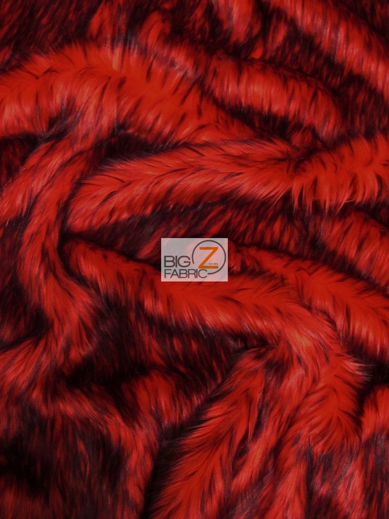 Może przedstawiać: Tkanina z czerwonego i czarnego sztucznego futra o długim włosiu. Tkanina jest miękka i puszysta, a jej wz&oacute;r jest w paski.
