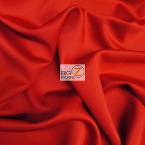 May include: A close-up shot of vibrant red fabric with soft folds and a smooth texture. The fabric has a slight sheen, creating highlights and shadows. The logo "BIG Z FABRIC" is visible in the upper right corner.