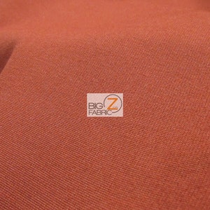 May include: Close-up of a rust-colored fabric with a subtle texture. The fabric is smooth and appears to be woven.