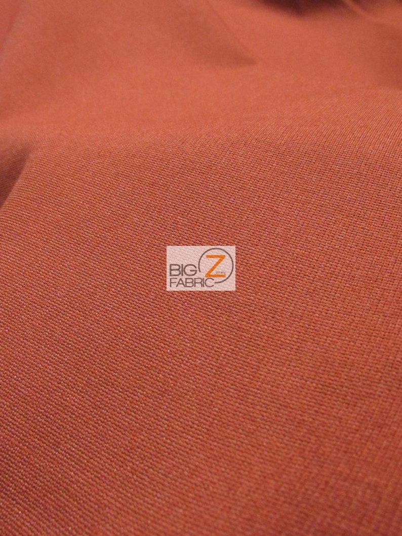 May include: Close-up of a rust-colored fabric with a subtle texture. The fabric is smooth and appears to be woven.