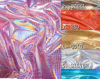 Op de afbeelding: Zes stofstalen in verschillende kleuren: roze, staal, rood, goud, zilver en turquoise. De stof is iriserend, heeft een textuur en een krokodilhuidpatroon.