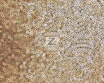 May include: A close-up of a gold sequined fabric. The sequins are small and round, and they are arranged in a swirling pattern.