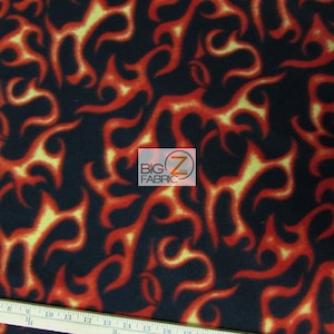 May include: Red and yellow flame pattern on black fleece fabric. The fabric is measured with a ruler in inches.