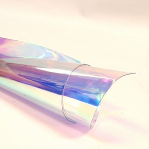 Puede incluir: Una l&aacute;mina enrollada de material iridiscente multicolor. El material refleja un espectro de colores, incluyendo rosa, azul y verde, con el texto "15. MULTI-COLOR" en la esquina superior izquierda.