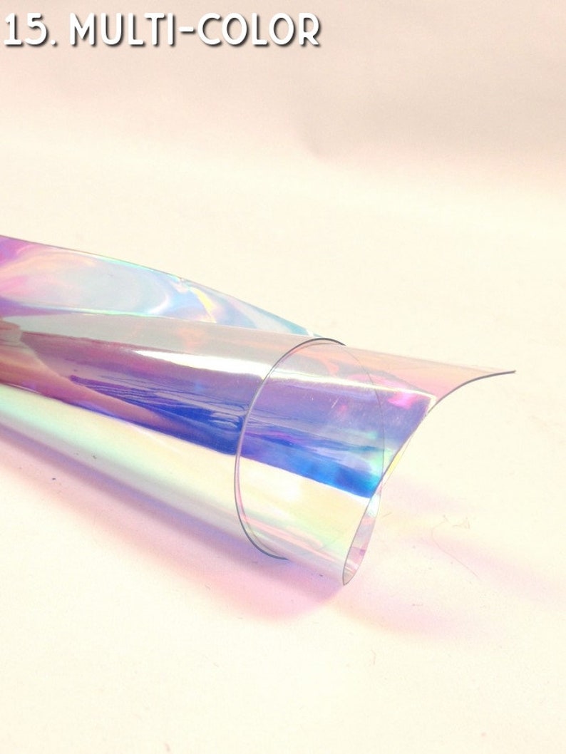 Puede incluir: Una l&aacute;mina enrollada de material iridiscente multicolor. El material refleja un espectro de colores, incluyendo rosa, azul y verde, con el texto "15. MULTI-COLOR" en la esquina superior izquierda.