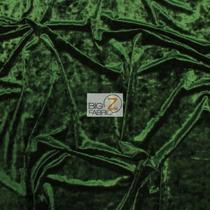 May include: A close-up of a deep green crushed velvet fabric. The fabric has a soft, plush texture and a subtle sheen.